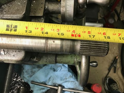 1996 Ford Bronco - Measuring a metal shaft with splines using a tape measure on a machine.