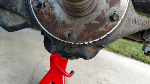 1992 Ford Bronco - Close-up of a vehicle spindle assembly, part number D159R, supported by a red jack stand.