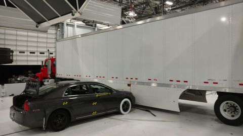 1971 Ford Ranchero - A car with impact sensors is positioned next to a large trailer in what appears to be a testing facility.