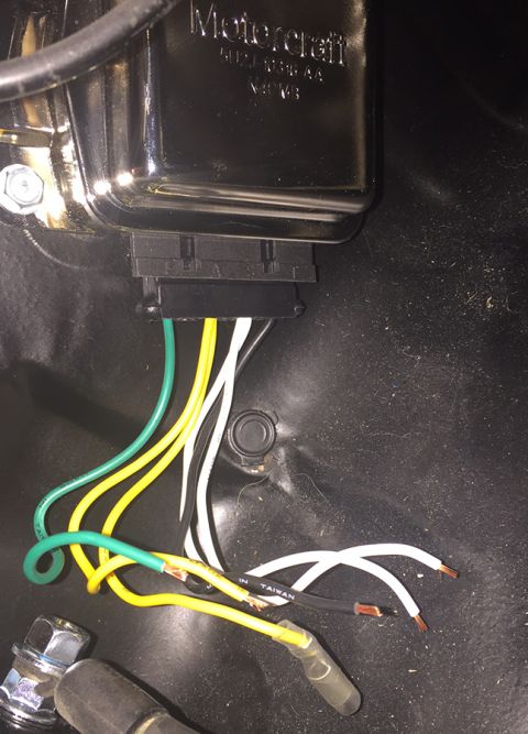 1978 Ford Bronco - Close-up of a Motorcraft voltage regulator with its wiring harness exposed and some wires showing stripped ends.