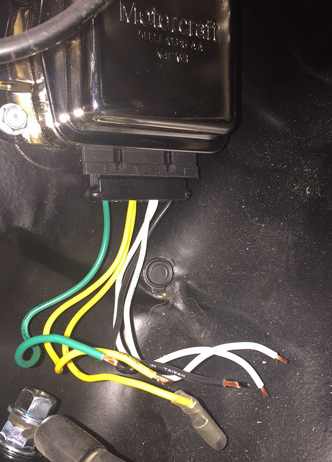 Wiring harness connected to a Motorcraft voltage regulator. Some wires are stripped