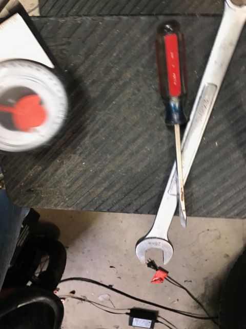 1996 Ford Bronco - Tools including a screwdriver and wrenches are laid out on a workbench next to a dial gauge.