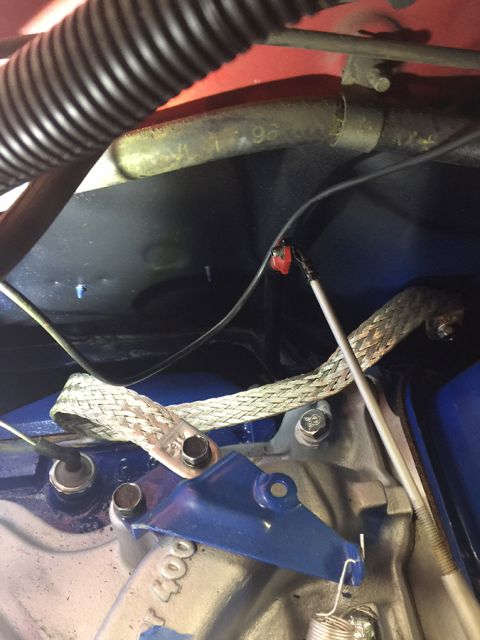 1978 Ford Bronco - Close-up view of engine bay wiring and a braided grounding strap attached to engine components.