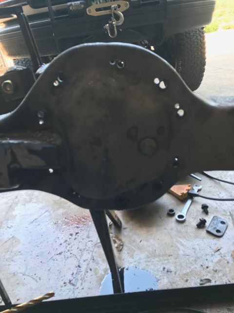 1996 Ford Bronco - A differential housing is shown with tools and hardware scattered around it.