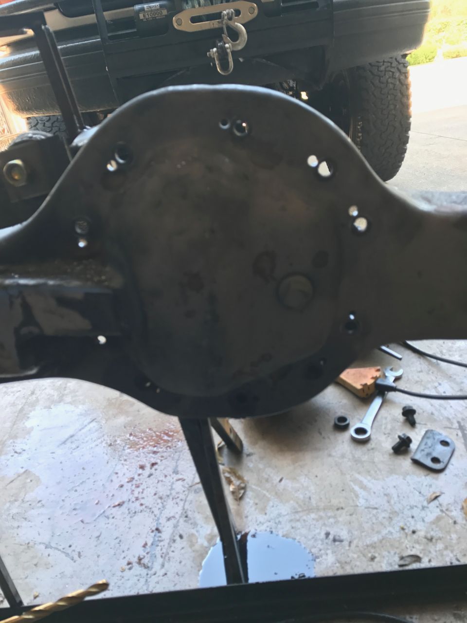 close-up of a differential housing with bolts and a wrench nearby