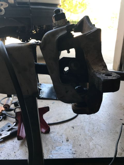 1996 Ford Bronco - This is a close-up view of a vehicle's steering knuckle assembly, showing wear and rust.