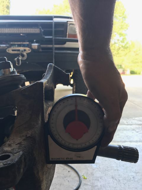 1996 Ford Bronco - Using an angle gauge to measure a suspension part during automotive work.
