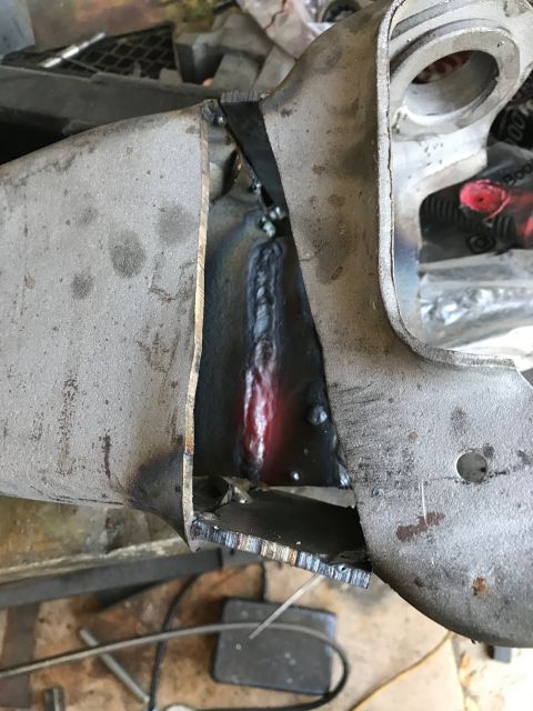 1996 Ford Bronco - A close-up view of a metal part that has been cut and welded, showing the fresh weld bead glowing red hot. The surrounding metal appears ag…