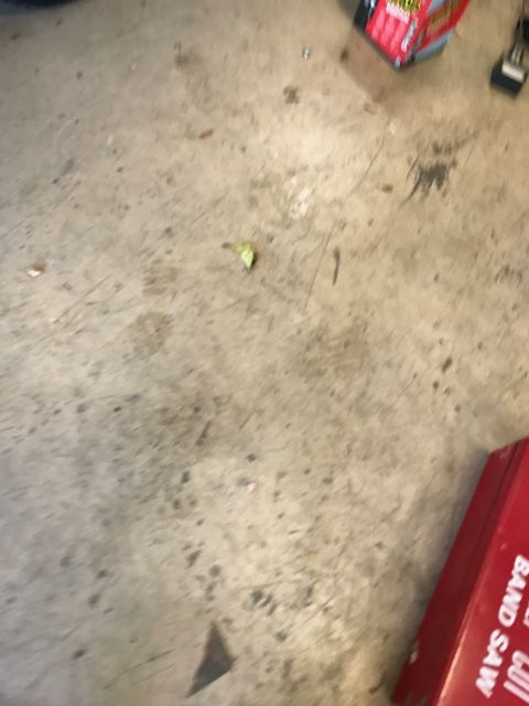 1996 Ford Bronco - A close-up view of a concrete floor with scattered debris and a red box in the corner.