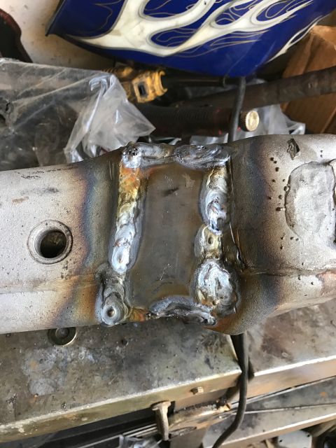 1996 Ford Bronco - A close-up view shows a metal component that has been welded, with visible heat discoloration and weld beads. The surrounding area includes…