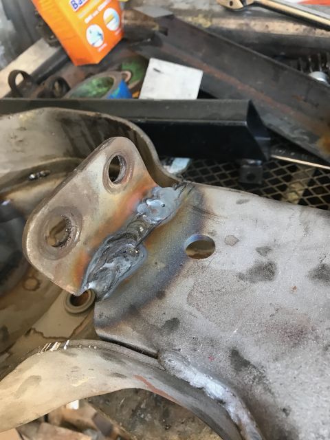 1996 Ford Bronco - A close-up view of a welded metal bracket, likely a vehicle part, with visible weld seams and bolt holes.