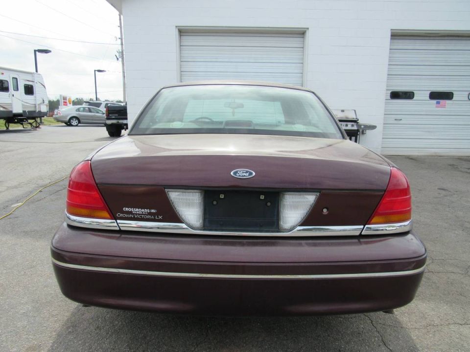2001 Ford Crown Victoria LX rear view. Burgundy paint, chrome trim, Ford emblem on trunk