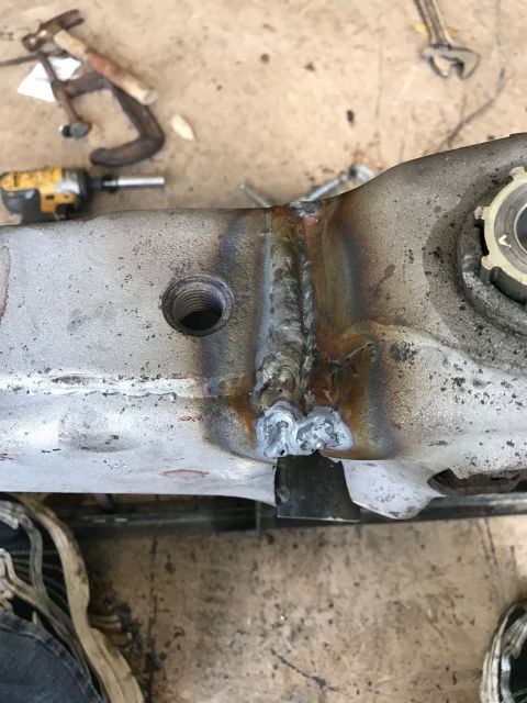1996 Ford Bronco - A close-up view shows a metal automotive part with visible welding repairs. Tools and a shoe are also present in the background.