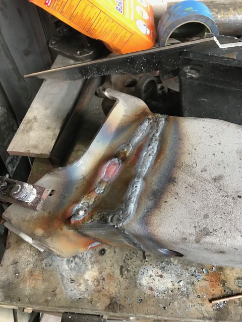 1996 Ford Bronco - A close-up view of a metal part that has been welded. The welds are visible, along with heat discoloration and some stamped numbers.