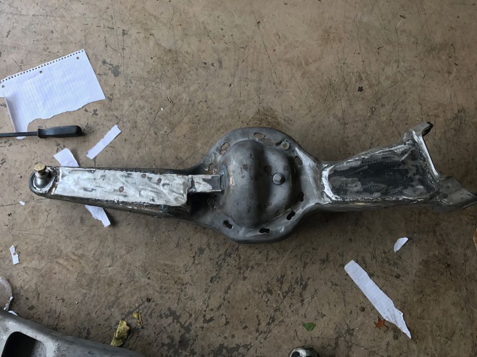 Metal differential housing with welded bracket and arm with ball joint.