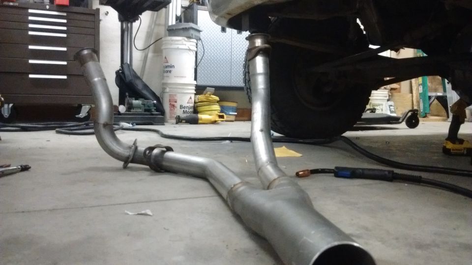 Custom Y-pipe exhaust system on a garage floor.
