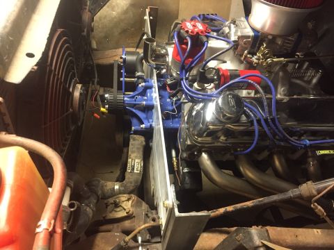 1982 Ford Bronco - A close-up, high-angle view of a modified V8 engine bay, showing chrome valve covers, blue spark plug wires, a carburetor, and exhaust head…