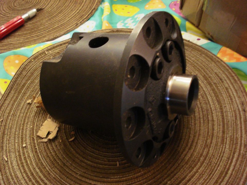 Dark metal differential part with silver cylinder on woven placemat.