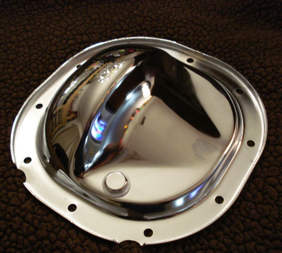 Chrome differential cover on a brown textured surface.