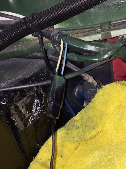 1978 Ford Bronco - A close-up view of wiring harness connections, including a black connector with three wires (white, blue, and black) emerging from it, secu…