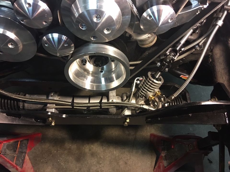 Overhead view of polished aluminum serpentine belt pulleys and power steering rack.
