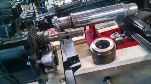 1985 Jeep CJ7 - A close-up view shows the internal gears of a vehicle's transmission, with a shiny metal shaft extending horizontally across the frame. A c…