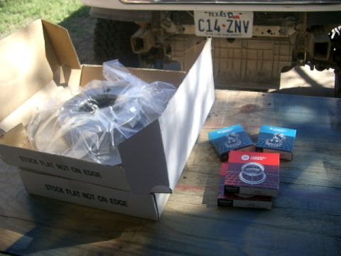 1994 Ford Bronco - New brake rotors and bearings are laid out on a table, with a vehicle's rear end visible in the background.