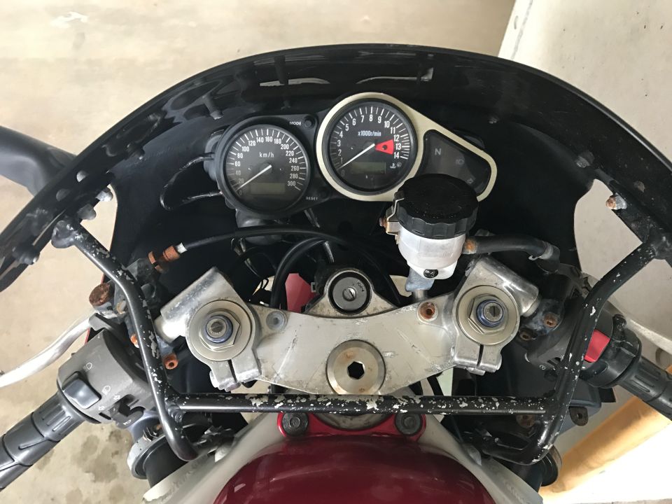 Motorcycle dashboard with speedometer, tachometer, and handlebars.
