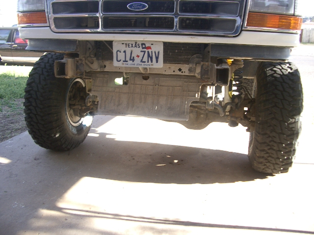 Front view of a modified 1992 Ford truck with large tires and a Texas license plate