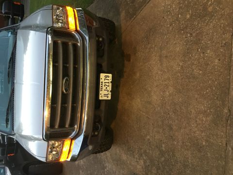 2004 Ford F-150 - The front view of a silver 2004 Ford F-150 truck is captured, showing its grille and headlights.