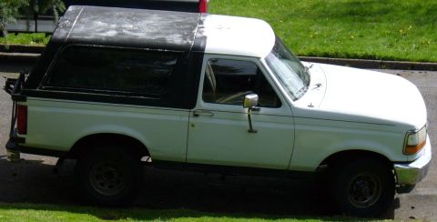 1992 Ford Bronco - Dirty wheels, faded roof.