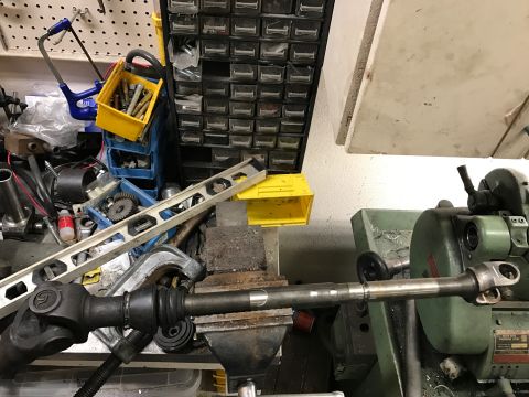 1996 Ford Bronco - A driveshaft is being worked on in a workshop setting, with a lathe and various tools visible.
