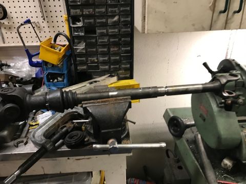 1996 Ford Bronco - A driveshaft component is secured in a vise, undergoing work with a metal cutting machine.