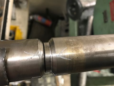 1996 Ford Bronco - Close-up of a machined metal part, likely a shaft, showing precise cuts and surface imperfections.