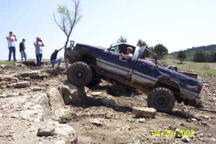 1979 Ford Bronco - Pickup truck navigates a rocky obstacle course with spectators observing the action.