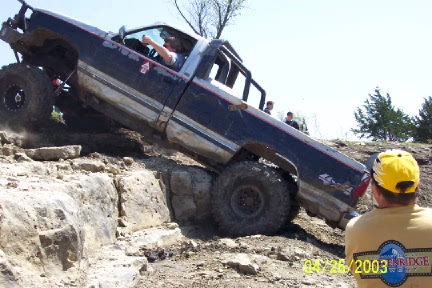1979 Ford Bronco - A modified pickup truck navigates a challenging rocky terrain during an off-road event.