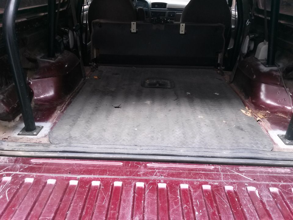 1996 Ford Bronco interior cargo area with rubber mat and rear seats folded