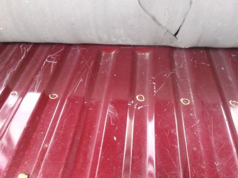 1996 Ford Bronco - Close-up of a red truck bed floor showing ribbed texture and surface marks.