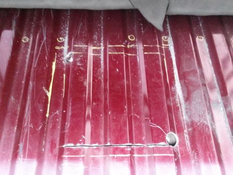 1996 Ford Bronco - This image shows a modified red metal panel with scribe lines and cutouts, likely part of a vehicle's fuel system access.
