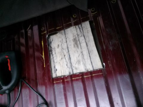 1996 Ford Bronco - Close-up of a vehicle's interior floor showing a cut-out panel and a tool, with a website logo visible.