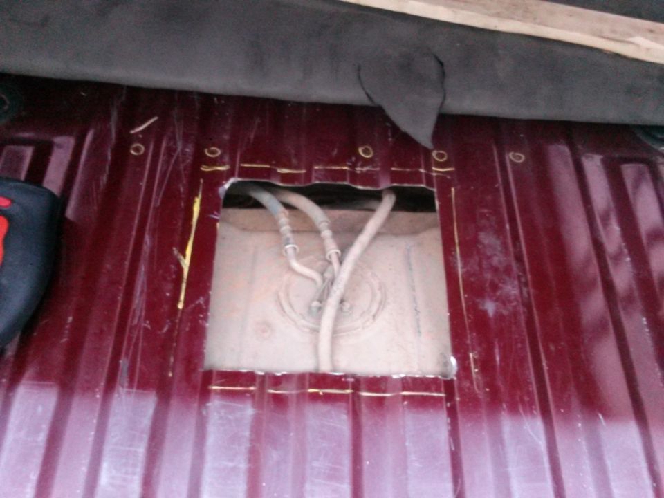 Fuel tank access panel removed, showing fuel lines and tank top