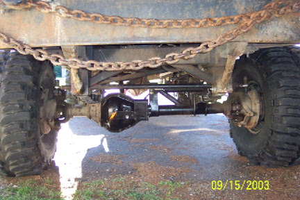1979 Ford Bronco - Undercarriage view of a vehicle's rear axle and suspension system, with heavy chains present.