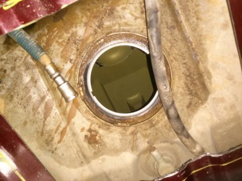 1996 Ford Bronco - Fuel tank opening with a hose attached, showing signs of wear and rust. Supermotors.net logo is present.