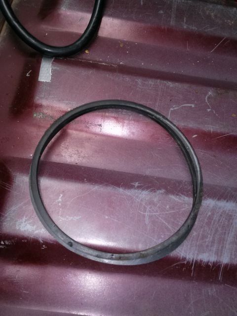 1996 Ford Bronco - A rubber ring, possibly a gasket, rests on a textured maroon surface.