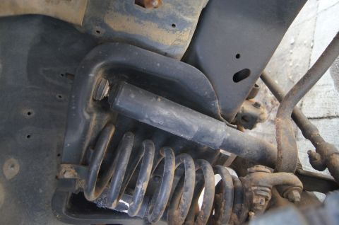 1986 Ford Bronco - This image shows the underside of a vehicle, focusing on the suspension system's coil spring and shock absorber.