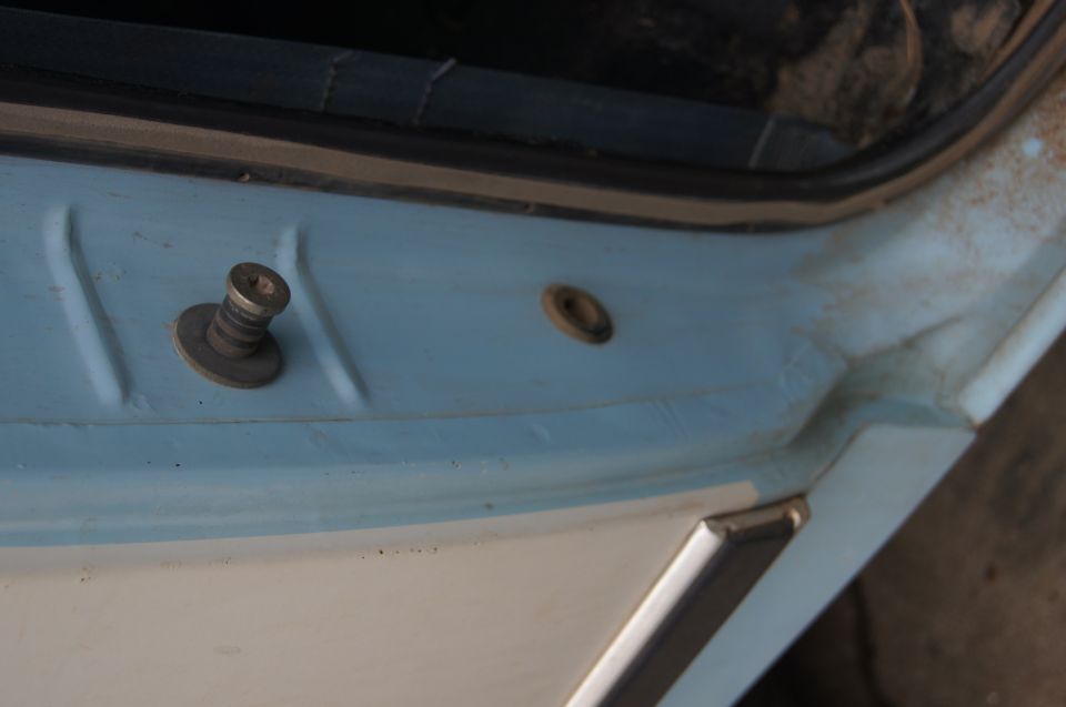 Door latch mechanism on a light blue and white vehicle interior, close-up