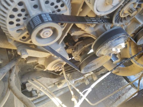 1988 Ford Bronco - Close-up of engine belts and pulleys, showing mechanical components.