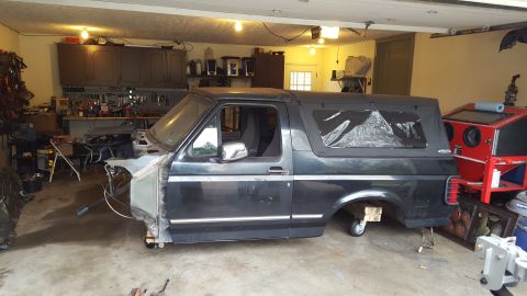 1994 Ford Bronco - This Ford Bronco is undergoing restoration in a garage, with its front end disassembled.