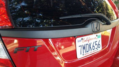 2015 Honda Fit - The rear of a red 2015 Honda Fit is visible, showing the 'FIT' badge and a California license plate.