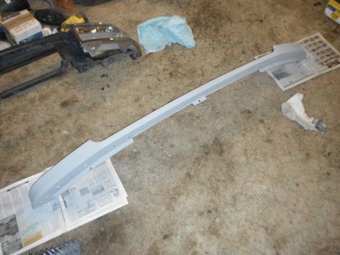 1995 Ford F-150 - A car fender trim piece is shown on the floor, possibly undergoing repair or modification.
